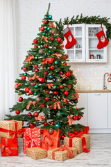 Christmas background: green tree decorated with red and green balls, Christmas decorations, yellow garlands. New Year. Gifts under the tree for the holiday
