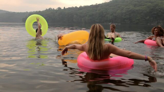 Friends floating on lake in inner tubes