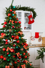 New Year decorations in the kitchen: a green tree decorated with red and green balls, New Year decorations, yellow garlands. New Year. Decorating the house for Christmas