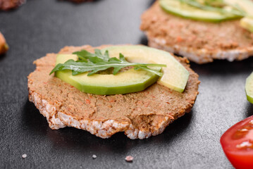 Tasty fresh sandwich with liver paste, avocado pieces and a arugula