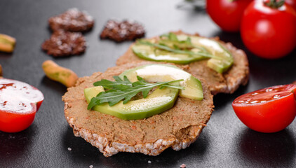 Tasty fresh sandwich with liver paste, avocado pieces and a arugula