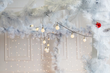 Decorations for the new year in white and a sparkling garland. Decorations in the house for Christmas.