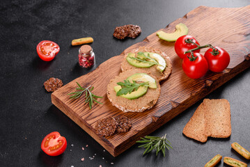 Tasty fresh sandwich with liver paste, avocado pieces and a arugula