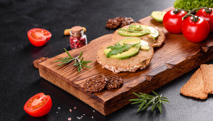 Tasty fresh sandwich with liver paste, avocado pieces and a arugula