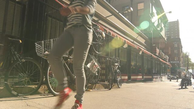 Young woman skipping on city sidewalk, New York City, New York, United States