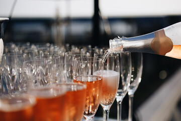 Rose champagne - sparkling wine in glasses; catering at reception for wedding or similar event