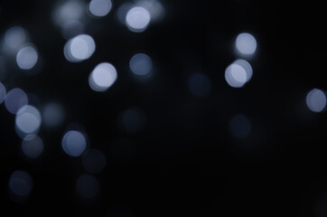 Fototapeta na wymiar Abstract pattern of white bokeh lights on black background