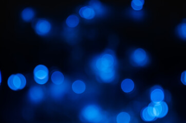 Abstract pattern of blue bokeh lights on black background