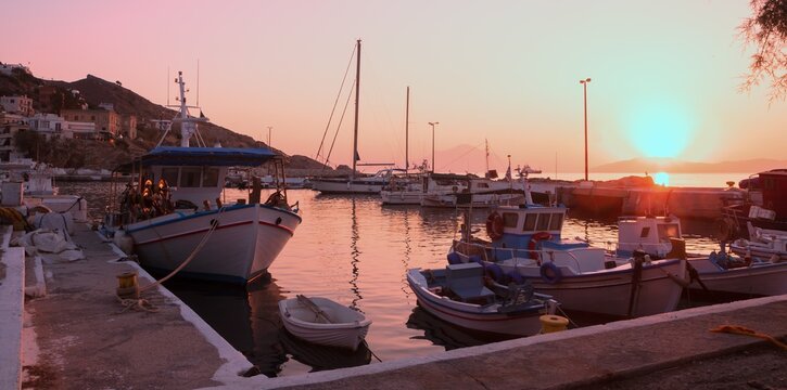 Romantic port of Agios Kirykos with traditional fishing boats at sunrise.