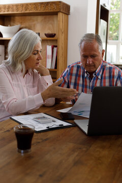 Stressed senior caucasian couple calculating finances at home