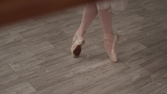 Close-up Of A Ballerina's Feet On Pointe Shoes, Taking Steps And Stretching Her Feet Before Class