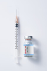 Covid-19 Written vaccine bottle with a syringe on a white background