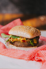 Hamburguesa veggie entre panes con salsa y hojas verdes