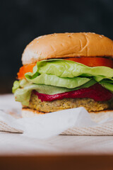detalle de hamburguesa con tomate y lechuga en fondo negro