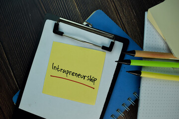 Intrapreneurship write on sticky notes. Isolated on Wooden Table.