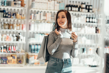 beautiful smiling Asian girl chooses buys cosmetics in the store. shopping