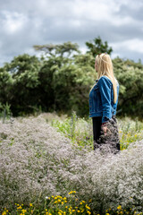 woman standing in a meadow full of wildflowers