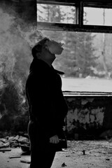 Guy vaping big clouds in abandoned house