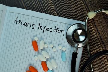 Ascaris Infection write on a book isolated on Wooden Table. Medical or Healthcare concept