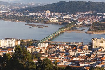 Fototapeta na wymiar Viana do Castelo Portugal view over the city red orange roofs rooftops hill mountain sunset warm light Limia river Ponte Eiffel bridge