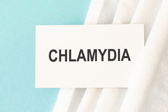 Word chlamydia with medical mask on a blue background.