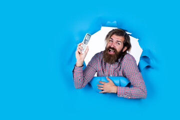 turn on and off the light. smart house. bearded man with tv remote control. brutal caucasian hipster change temperature on air conditioner. unshaven guy with control his life