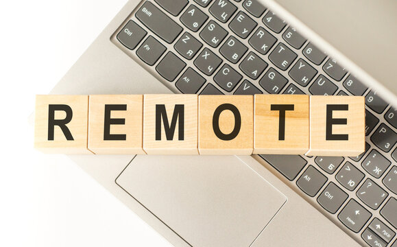 Word remote. Wooden cubes with letters isolated on a laptop keyboard. Business Concept image.