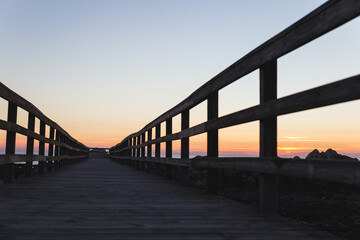 Fototapeta na wymiar Praia do Coral sunset Viana do Castelo Portugal shore coast beach rocks sand footbridge pathway