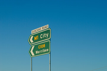 The road signs of M1 Princes Freeway to city and road c108 to Werribee against the blue sky. Melbourne, VIC Australia. Copy space for text.