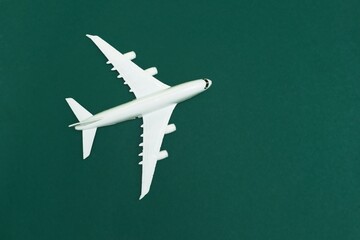White passenger plane on green tide background. View from above.