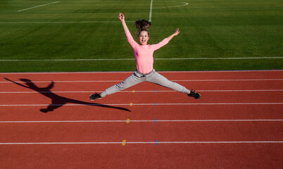 Obraz premium girl kid jump high outside on stadium arena, energy