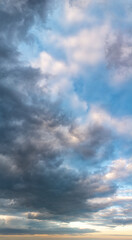Fototapeta premium Fantastic clouds at sunrise, vertical panorama