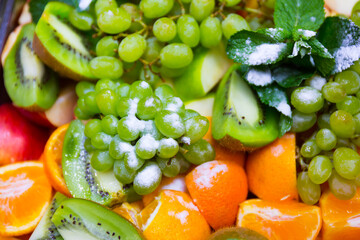 Served tasty fruits on dish in restaurant close up view.