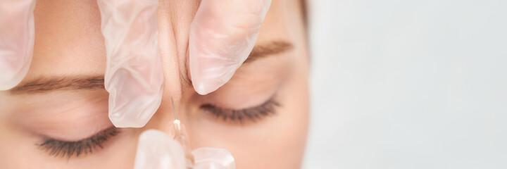 Forehead injection at spa salon. Doctor hands. Closeup. High quality. Pretty female patient. Beauty...