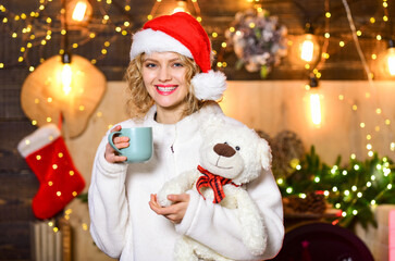 Plan for some interesting Christmas activity. Girl with mug hot beverage relaxing. Things to do before christmas. Woman with teddy bear drink tea christmas decorations background. Relax and recharge