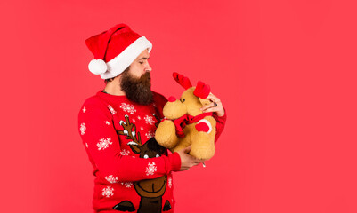 Gifts for kids. Dear Santa. Bearded man reindeer toy. Hipster man hold Christmas gift. Happy man playful mood. Plush deer. Happy new year. Helping Santa Claus. Symbol of Christmas. Christmas eve