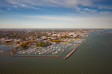 Incredible aerial city skyline panorama photograph of Sandusky, Ohio from the shoreline of the bay in Lake Erie with parks and harbors seen below on a sunny day near Battery Park.
