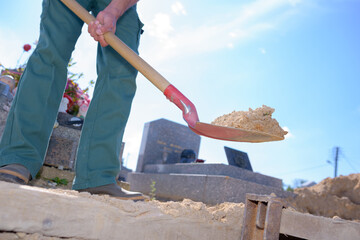 portrait of a worker digging a grave