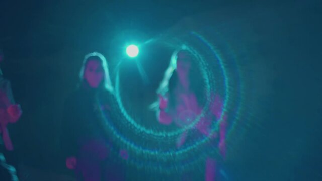 Group of millennials dancing on roller skates in dark studio. Teenagers spending time together freeskating and showing moves, having good time. View on nightlife youth culture. Concept of lifestyle.
