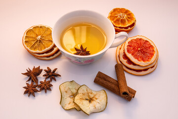 Creative layout of tea cup with dried fruits, cinnamon and anise stars