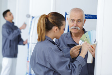 Obraz premium painting and decorating colleagues looking at colour samples