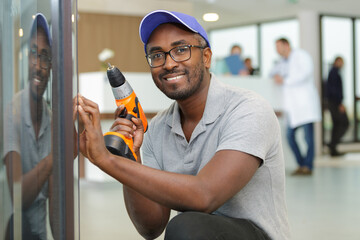 handyman crouching to use a cordless screwdriver