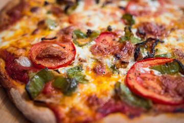 Most beautiful and delicious homemade vegetarian pizza just getting out of the pizza oven (marinara sauce, tomatoes, green peppers, mozarella cheese). Professional italian cooking. Macro close up.