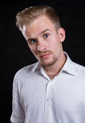 Young man dressed in white shirt studio portrait