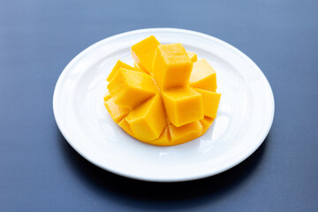 Tropical fruit, Mango on white plate on dark background.