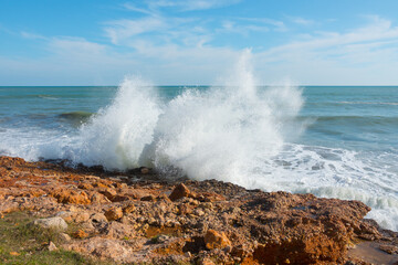 Beautiful waves crashing against the shore in Alcossebre, Spain. Sunny summer day with a wild ocean. 