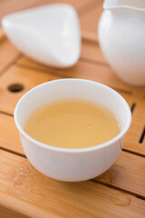Beautiful porcelain tea cup close up shot. Hydrating pale liquor in it.
Fresh natural Si Ji Chun, a rolled oolong tea. Vertical shot.