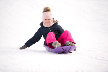 Fototapeta na wymiar une petite fille fait de la luge