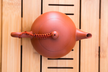 Beautiful brown clay teapot on a bambou tray. Used for Gong Fu Cha. Traditional asian way of drinking the hot beverage. Professional teaware, perfectly aligned.