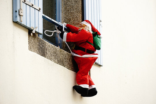 P&egrave;re noel grimpant &agrave; la fen&ecirc;tre .